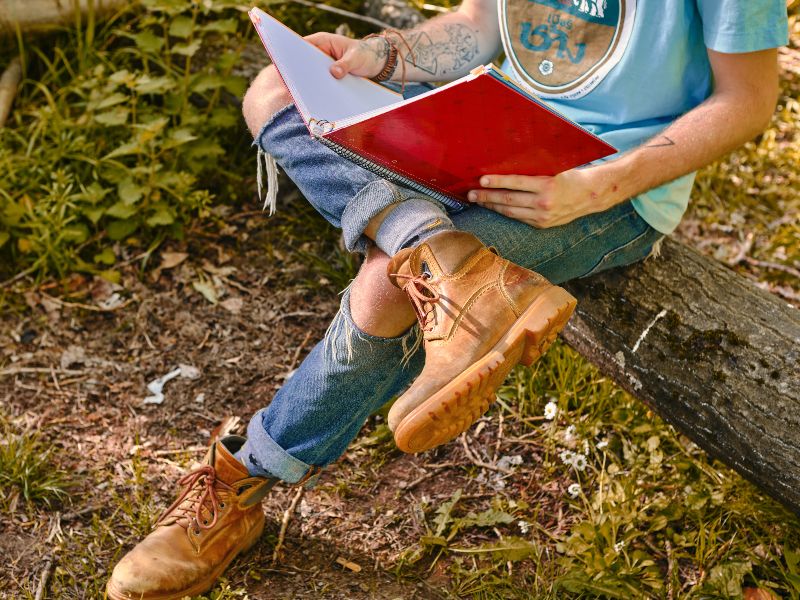 student studying with notebook in forest
